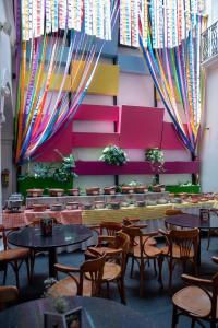 ein Restaurant mit Tischen und Stühlen und farbenfrohen Wänden in der Unterkunft Del Carmen Concept Hotel Boutique by Chai in Guadalajara