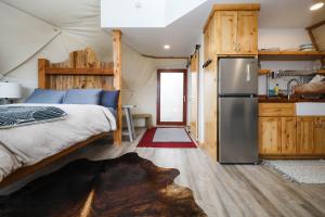 a bedroom with a bed and a refrigerator in a tent at Pure Heart Retreat in Cody