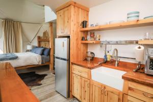 a kitchen with a refrigerator and a bed in a tent at Pure Heart Retreat in Cody