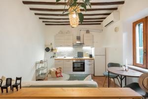 a kitchen and a living room with a table and chairs at Porta Toscana in Poggibonsi +10 photos