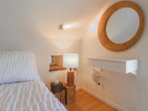 a bedroom with a bed with a mirror and a lamp at Little Barn in Leek
