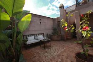 a patio with a couch and a table at Riad Khalid Zrika Marrakech in Marrakesh