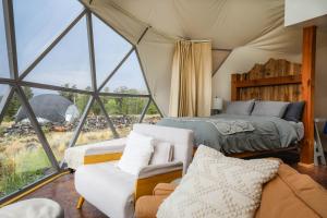 a bedroom in a tent with a bed and a couch at Pure Heart Retreat in Cody
