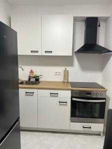 a kitchen with white cabinets and a stove top oven at Ferienwohnung zum Buchhellertal in Burbach +11 photos