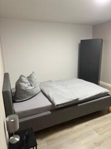 a bedroom with a bed and a black cabinet at Ferienwohnung zum Buchhellertal in Burbach