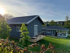 a gray house with a deck and a yard at Žalčio guolis in Lekėčiai +21 photos