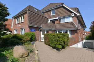 ein Backsteinhaus mit einem Backsteingang davor in der Unterkunft Appartementhaus Nige Ooge Ferienwohnung Nr. 1 in Cuxhaven