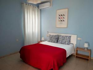a bedroom with a white bed with a red blanket at Apartamento Casa Balina II in Dúrcal