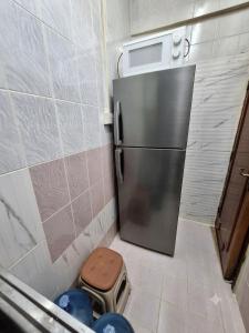 a stainless steel refrigerator in a small kitchen at Hidden Villa in Al Ain