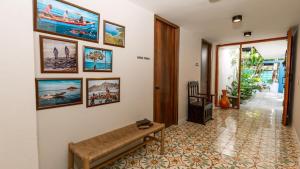 a living room with a bench and pictures on the wall at Hotel Libreria Cafe de Pombal in Santa Marta