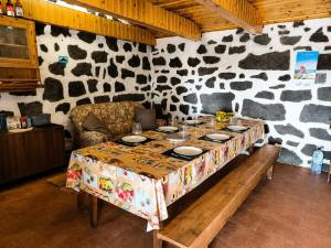 a table in a room with a cow print wall at Adega do Carlos Pinheiro in São Roque do Pico