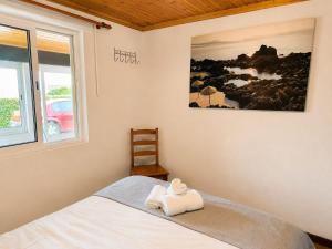a bedroom with a bed with a towel on it at Adega do Carlos Pinheiro in São Roque do Pico