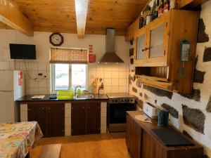 a kitchen with wooden cabinets and a counter top at Adega do Carlos Pinheiro in São Roque do Pico +9 photos