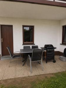 a patio with chairs and a table and a grill at Ferienwohnung mit Pool und Sauna - Medebach in Medebach