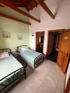 a room with two beds and a room with a door at A Casa dos Meus Sonhos in Santo Amaro