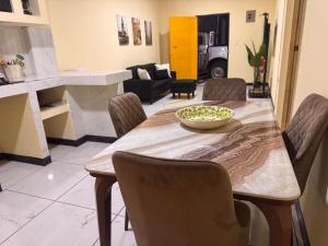 a dining room table with chairs and a bowl on it at The Cozy House in Estelí