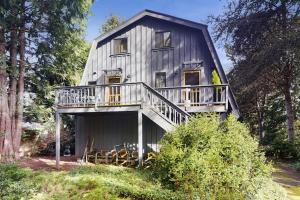a large house with a deck on the side of it at Tranquil Tides Cottage in Langley