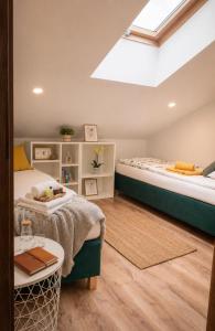 a attic bedroom with two beds and a skylight at OsiedLOVE Poddasze in Jędrzejów