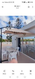 a picture of a patio with a table and umbrella at Skhirat terrace apartment at the beach in Skhirat