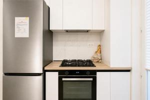 a kitchen with a stove and a refrigerator at Sasha Wave Studio in Popeşti-Leordeni