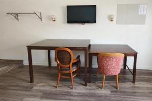 a wooden table with two chairs and a television at Del Playa Inn Oxnard Near Camarillo in Oxnard +11 photos