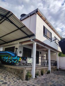 a white house with a balcony with a inflatable at Naru CasaBlanca in Utica