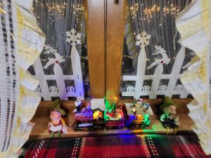 a toy house with a train and christmas lights at Deda Mrazova kućica in Knić