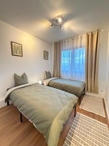 two beds in a room with a window at Le Cosy in Dunkerque