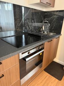 a kitchen with a black counter top and a sink at Le Cosy in Dunkerque +5 photos
