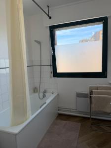 a bathroom with a window and a tub and a shower at Le Cosy in Dunkerque