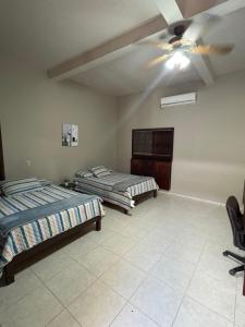 a bedroom with two beds and a ceiling fan at Dormitorio in Juticalpa