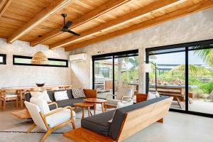 an open living room with a couch and chairs at Seabird Villa 3 in Placencia +44 photos