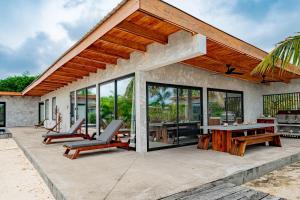 a house with a patio with a table and chairs at Seabird Villa 3 in Placencia