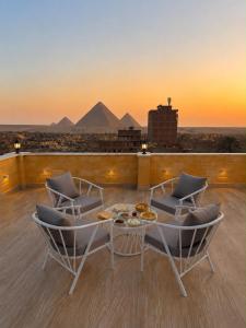 a balcony with chairs and a table and pyramids at Royal Pyramids Hotel in Cairo