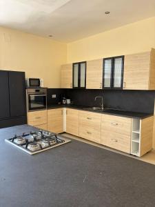 a kitchen with wooden cabinets and a stove top oven at Belle Villa Kassonyah, Conakry in Conakry