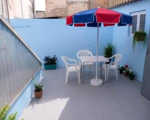 a table and chairs under an umbrella on a balcony at Maison traditionnelle cadablabca centre in Casablanca