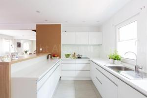 a white kitchen with white cabinets and a sink at Leśna Willa ŚWIT in Holendry +16 photos