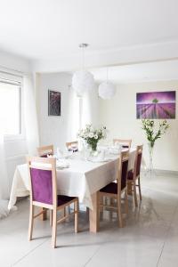 a white dining room with a white table and chairs at Leśna Willa ŚWIT in Holendry