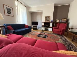 a living room with a couch and two red chairs at Santa Marta Apartment in Biella