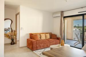 a living room with a couch and a table at Le Cocon d'Orezza - Appart Climatisé avec Balcon in Penta-di-Casinca