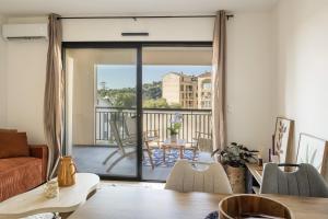 a living room with a view of a balcony at Le Cocon d'Orezza - Appart Climatisé avec Balcon in Penta-di-Casinca