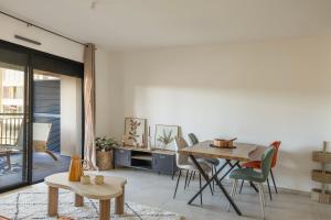a living room with a table and chairs at Le Cocon d'Orezza - Appart Climatisé avec Balcon in Penta-di-Casinca