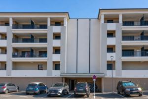 a parking lot with cars parked in front of a building at Le Cocon d'Orezza - Appart Climatisé avec Balcon in Penta-di-Casinca +4 photos