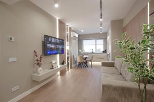 a living room with a couch and a tv on a wall at Bacovia Grand Apartment- Free Parking in Bacău