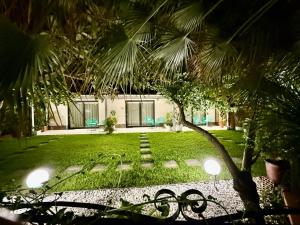 a yard with a house with chairs and a tree at Casetta Giardinetto in Altavilla Milicia