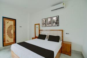 a bedroom with a large bed with black and white sheets at SPOT ON Golden Eagle Residency in Barpeta +34 photos