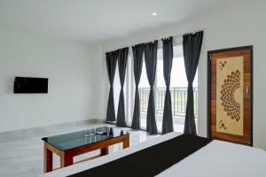 a bedroom with a bed with a desk and a window at SPOT ON Golden Eagle Residency in Barpeta