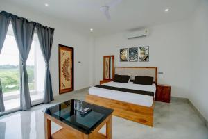 a bedroom with a bed and a table in a room at SPOT ON Golden Eagle Residency in Barpeta