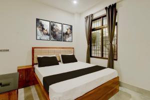 a bedroom with a bed and a window at SPOT ON Golden Eagle Residency in Barpeta