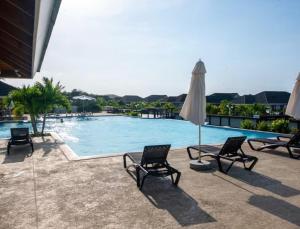 a swimming pool with chairs and an umbrella at Apartment in St Ann in Priory